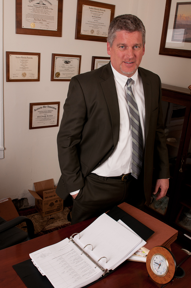 Attorney Paul J. Dickman standing at his desk at the Dickman Law Office